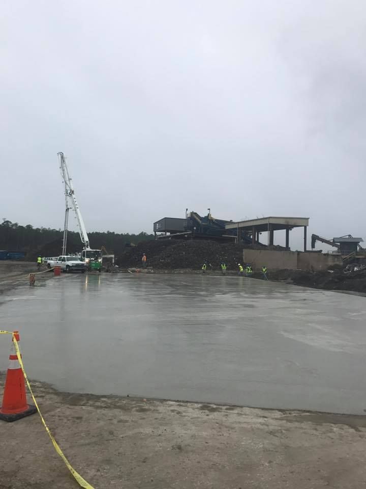 A construction site with a lot of concrete and a crane in the background.