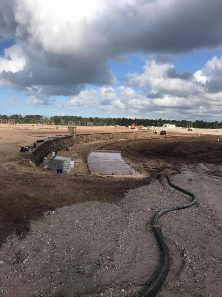 A large dirt field with a hose in the middle of it.