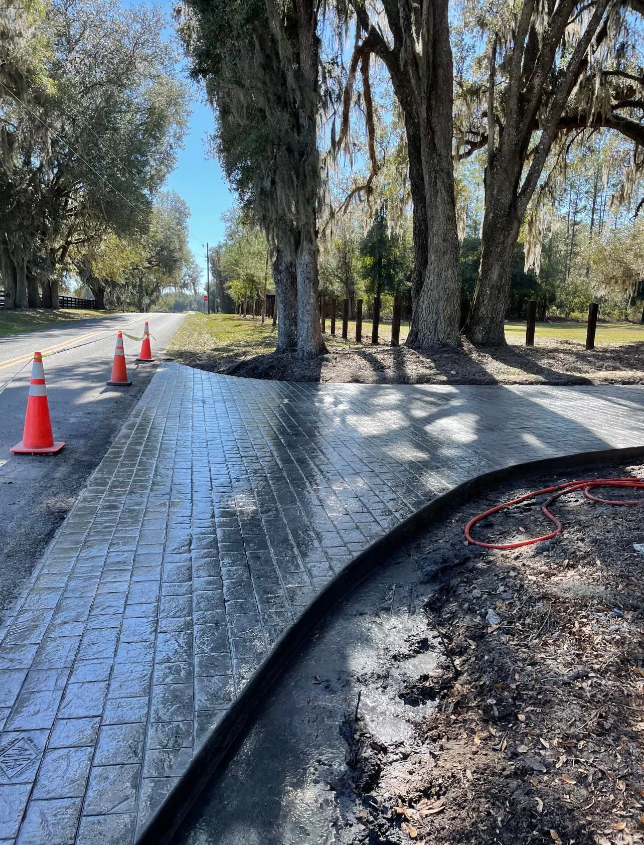 A brick walkway is being built on the side of a road.