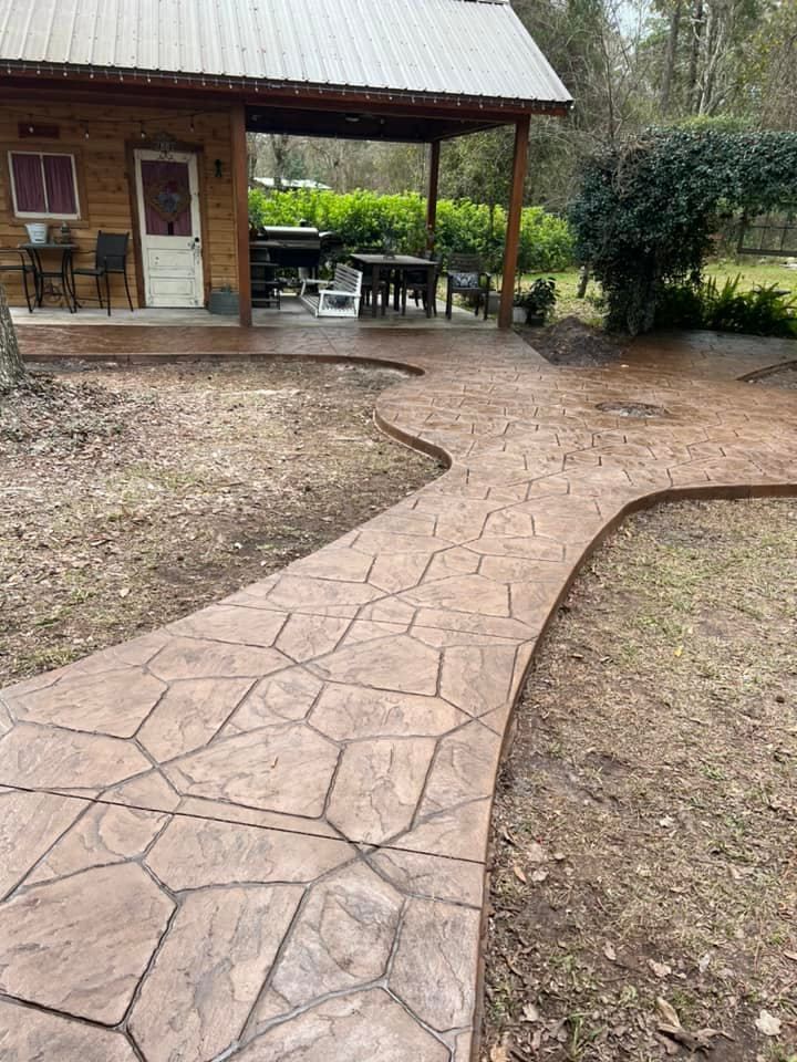 A concrete walkway leading to a cabin in the woods.