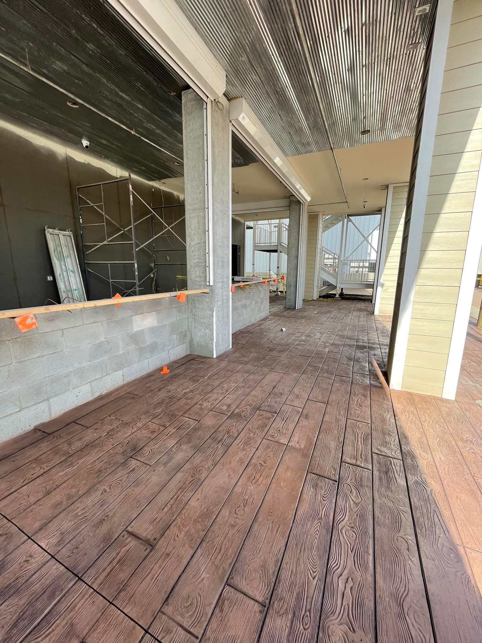 A large empty room with a wooden floor and a large window.