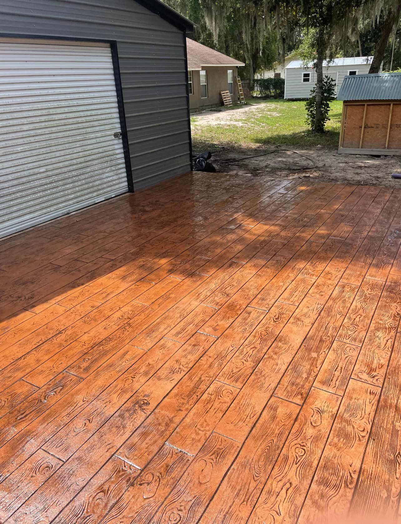 A concrete patio with a garage in the background.