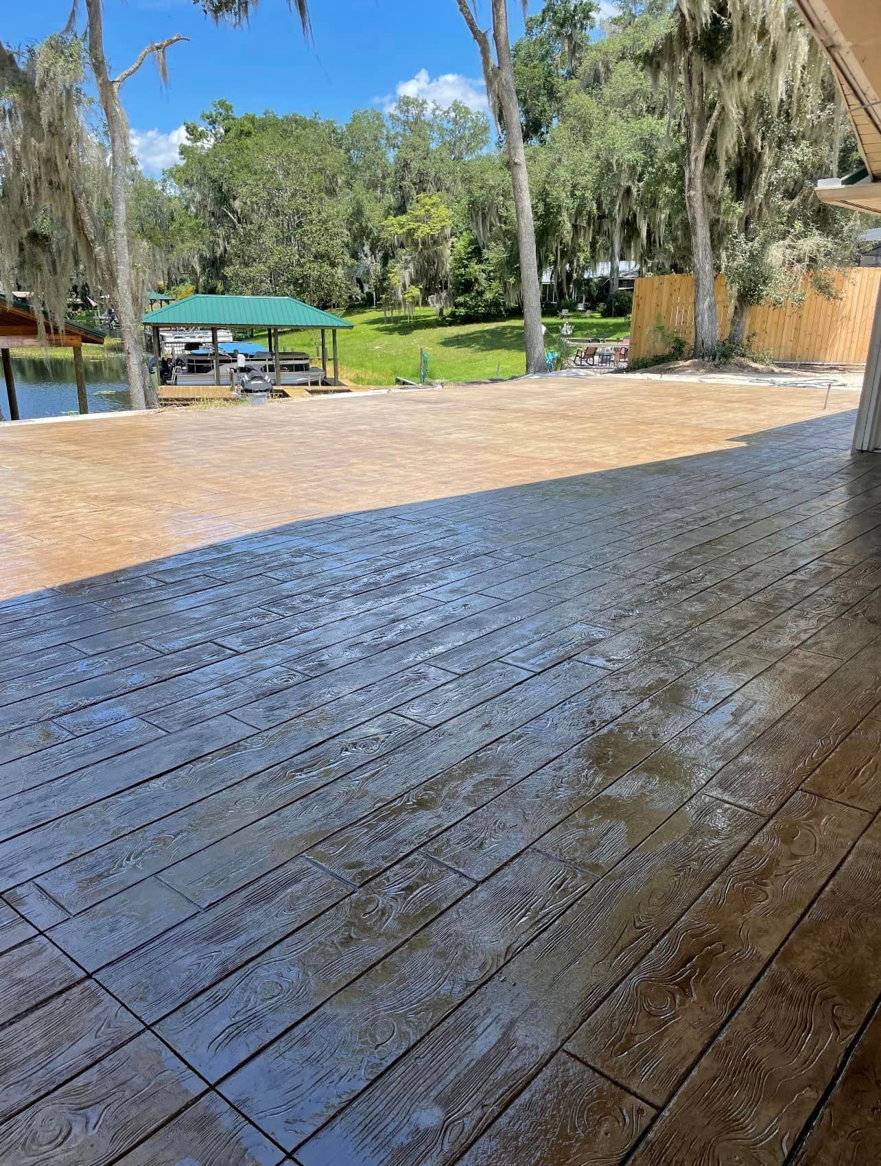 A concrete deck with a view of a lake and trees.