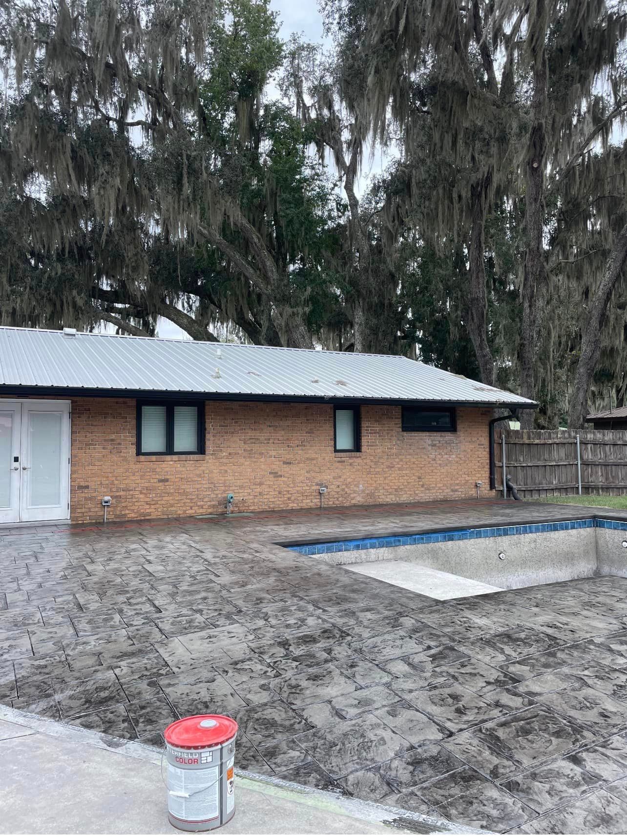A brick house with a swimming pool in front of it.