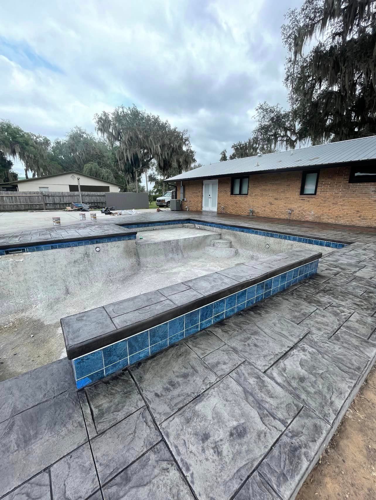 A brick house with a swimming pool in front of it.