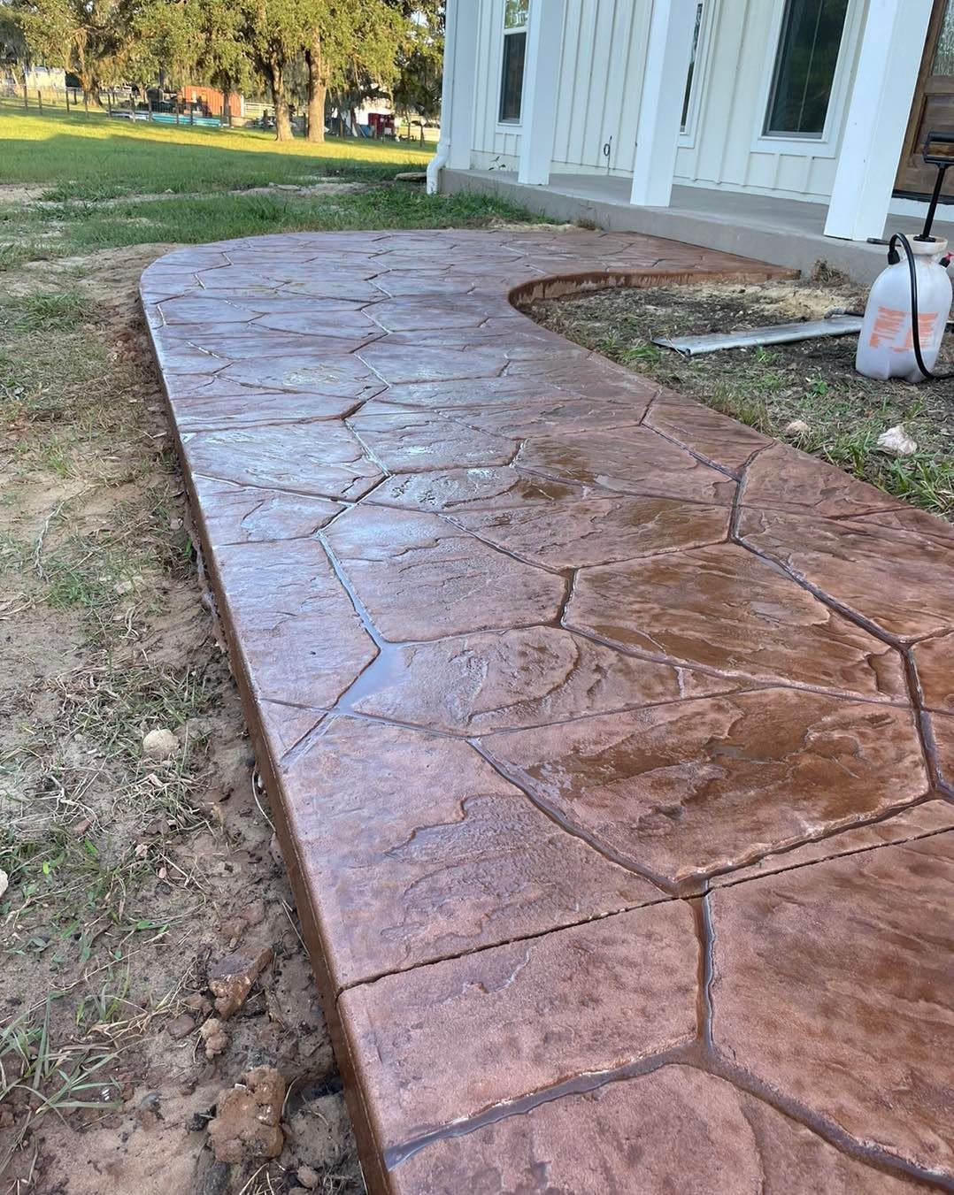 A concrete walkway is being built in front of a house.