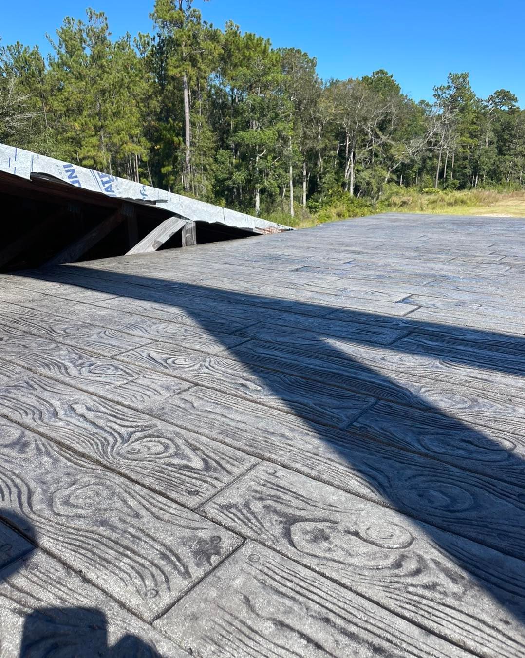 A wooden deck with a shadow of a person on it.