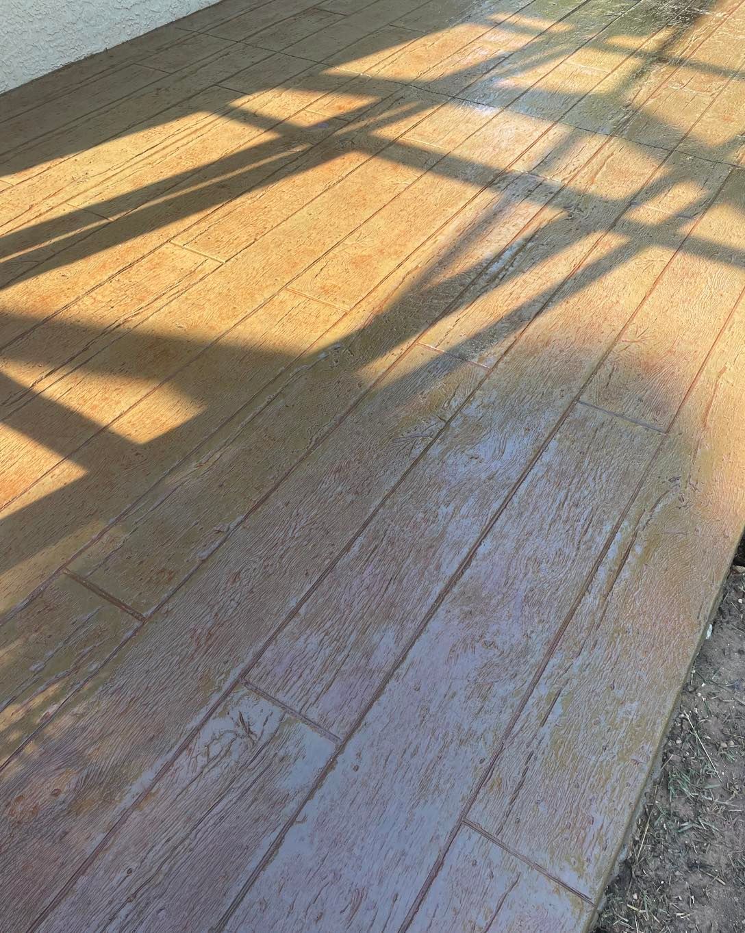 A wooden floor with a shadow of a window on it.