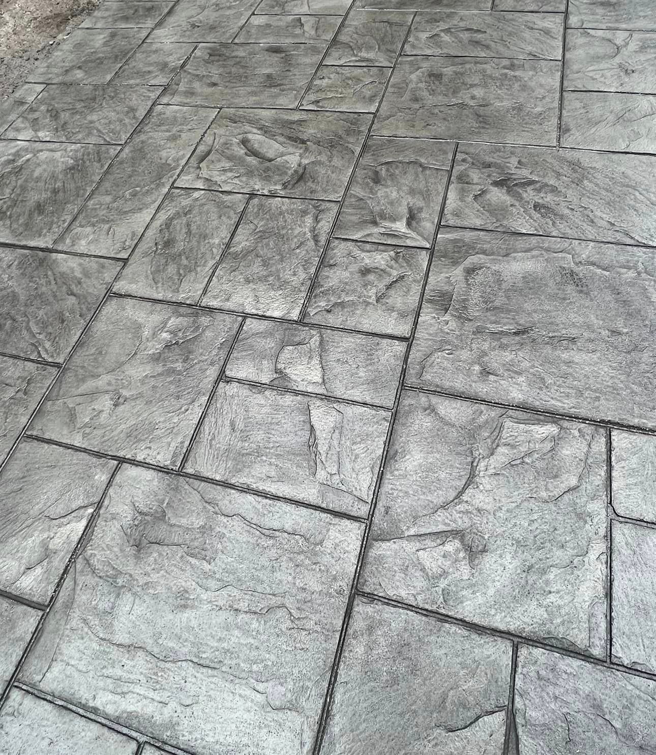 A close up of a concrete floor with a pattern of squares.