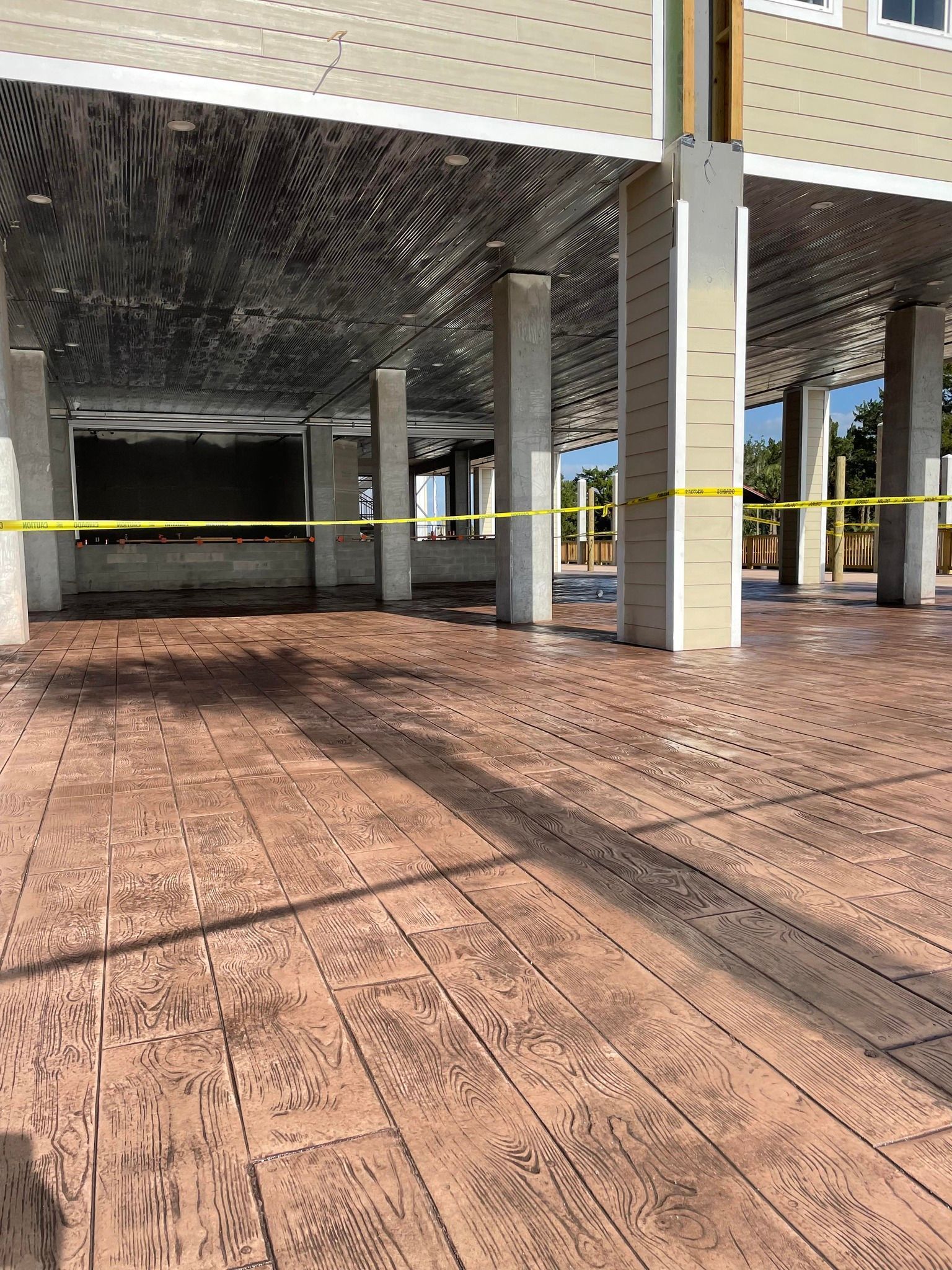 A large concrete floor with columns and a yellow tape.