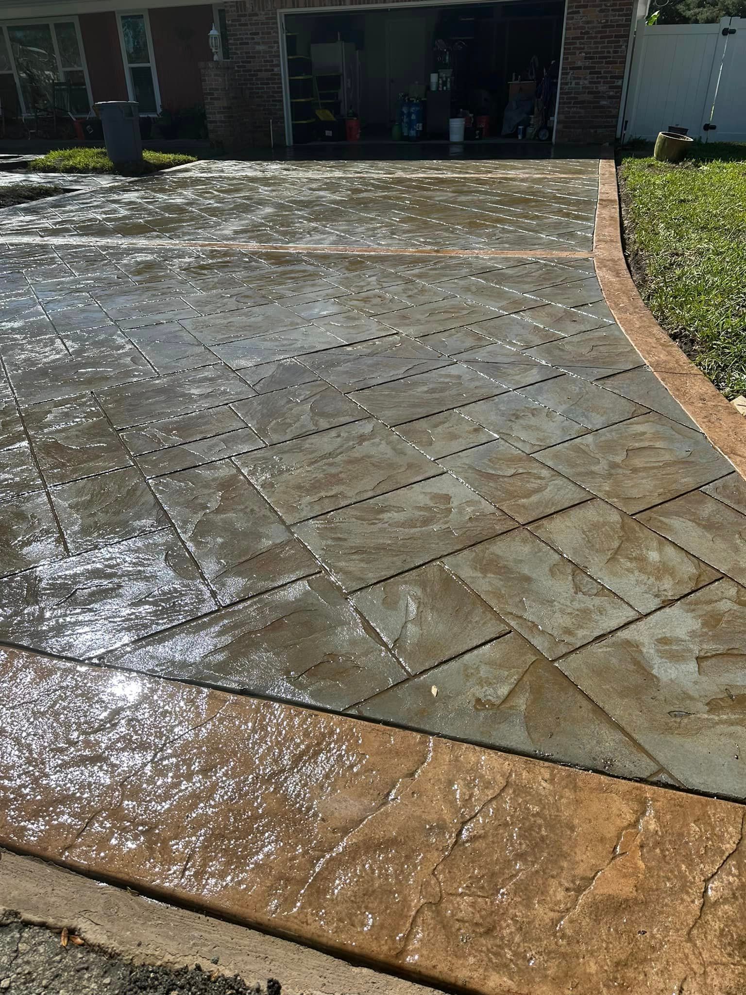 A concrete driveway with a brick house in the background.