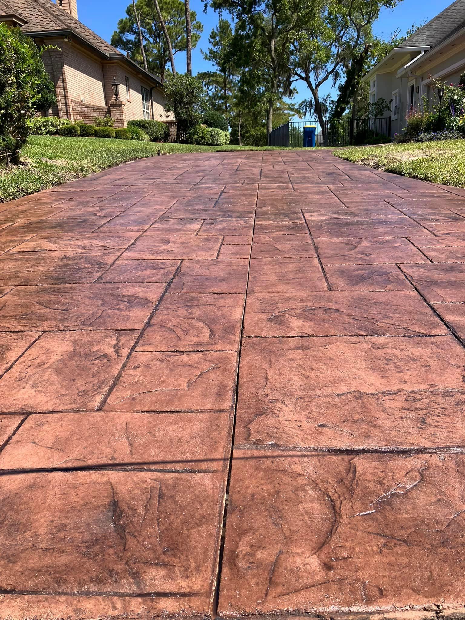 A brick driveway leading to a house on a sunny day.