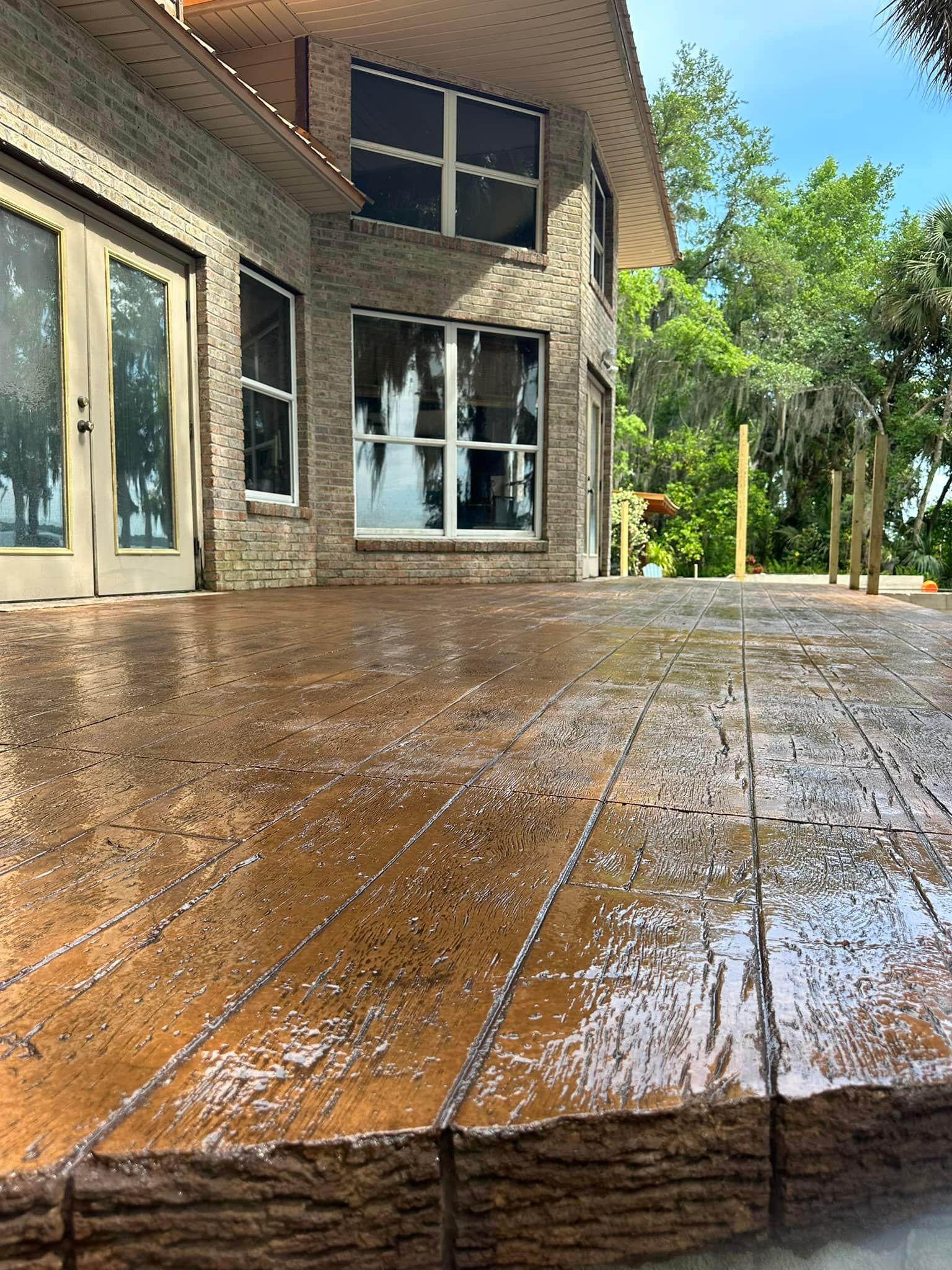 A large brick house with a wooden deck in front of it.
