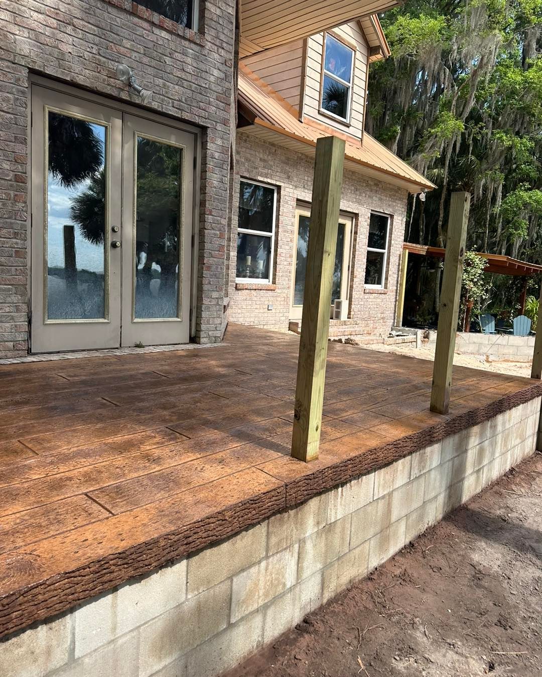 A brick house with a wooden deck in front of it.
