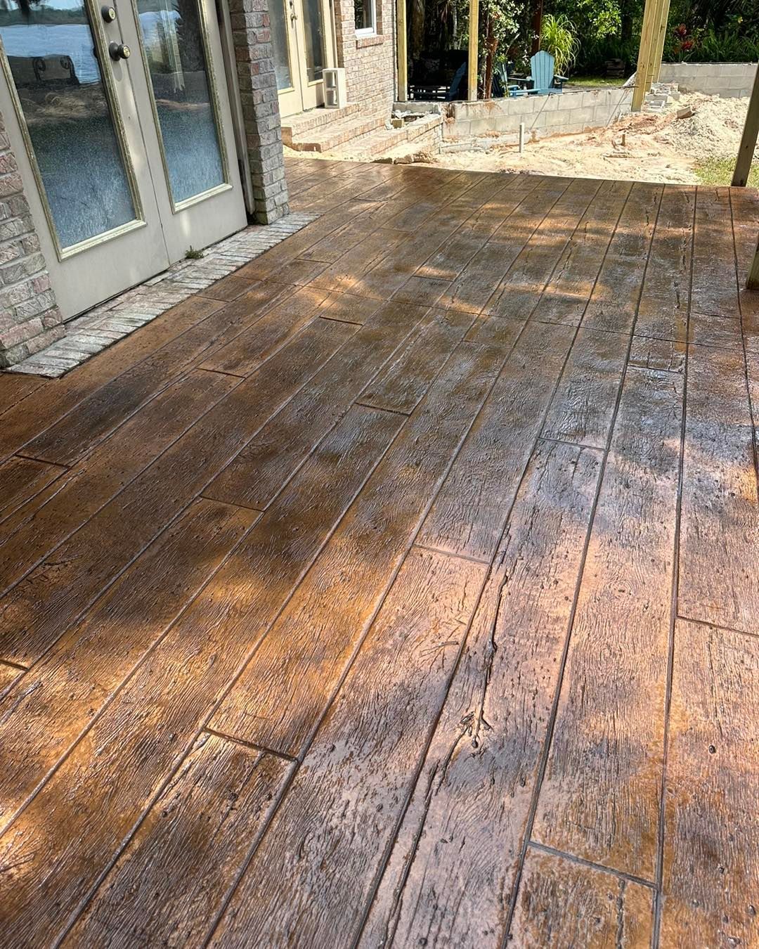 A patio with a concrete floor that looks like wood.