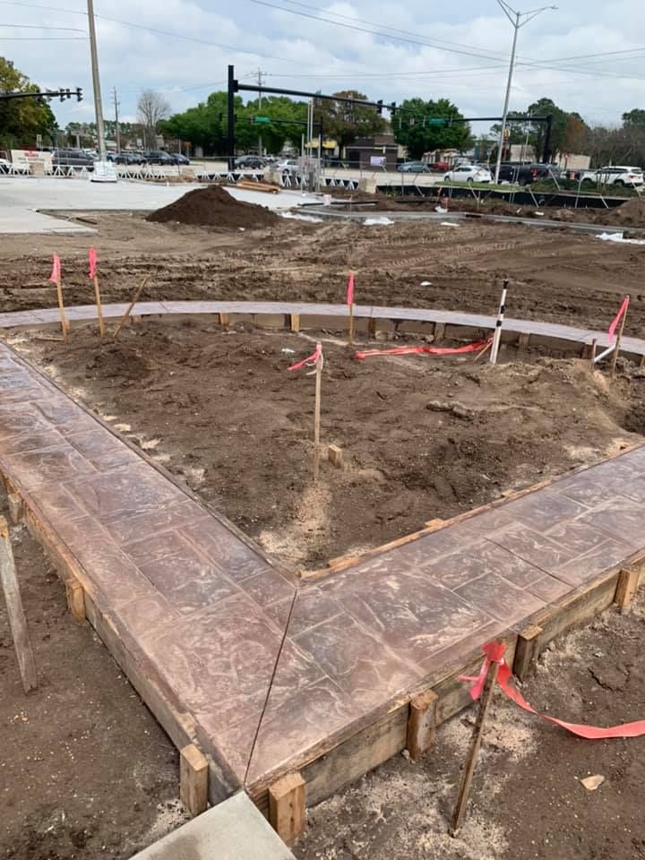 A concrete walkway is being built in a dirt field.