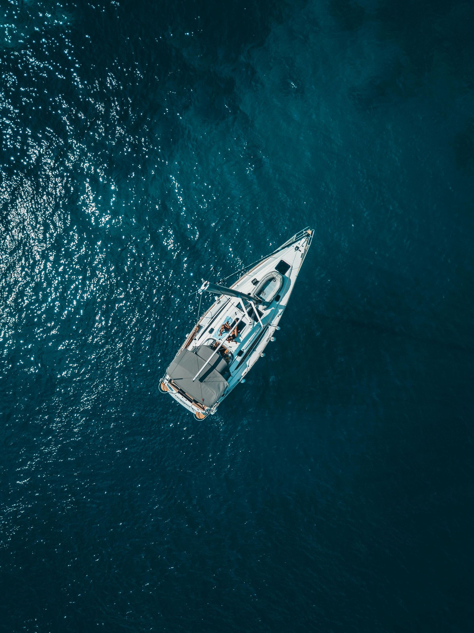 An aerial view of a sailboat in the ocean