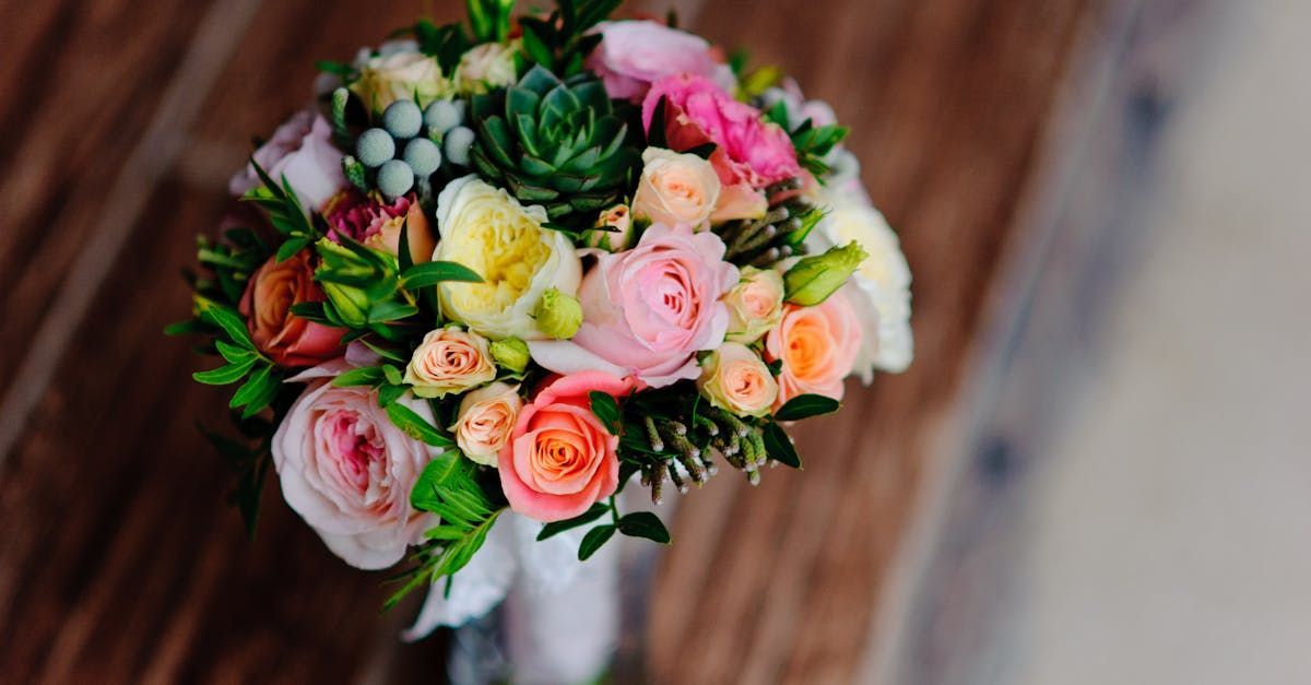 A bouquet of flowers is sitting on a wooden table.