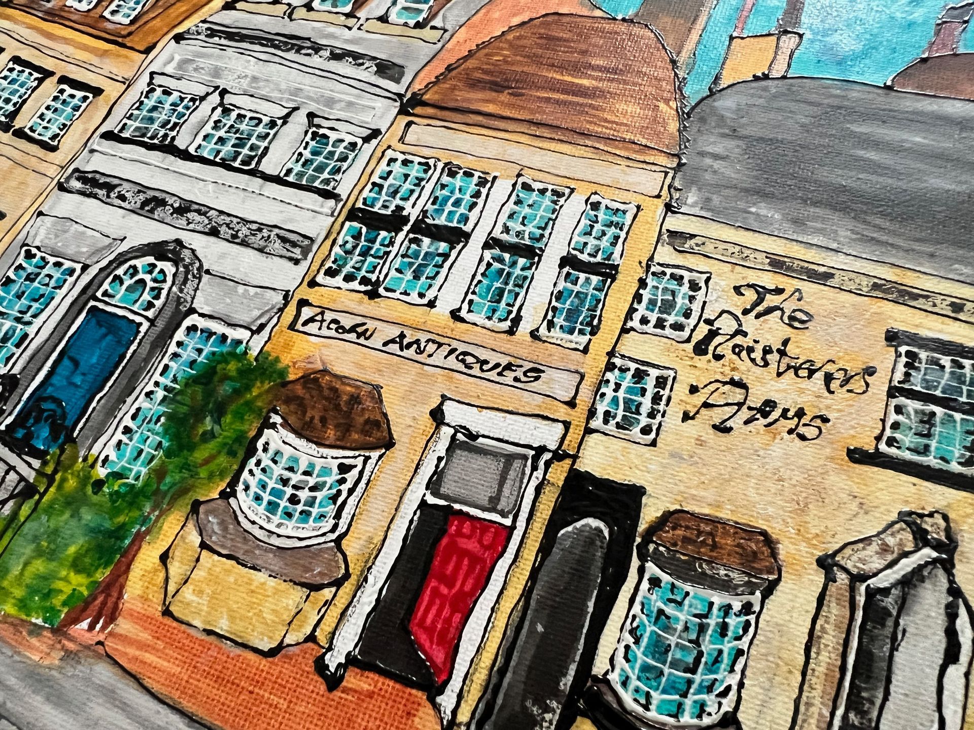 Watercolor illustration of buildings, storefronts with “Andy Antiques” and “The Mustard Pot Arms” signs.