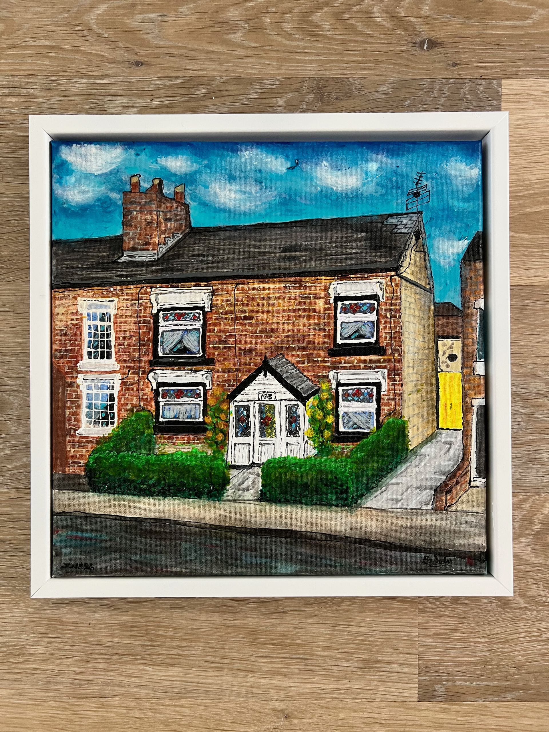 Yellow house painting, blue sky, green lawn and tree. White windows, front door, and walkway.
