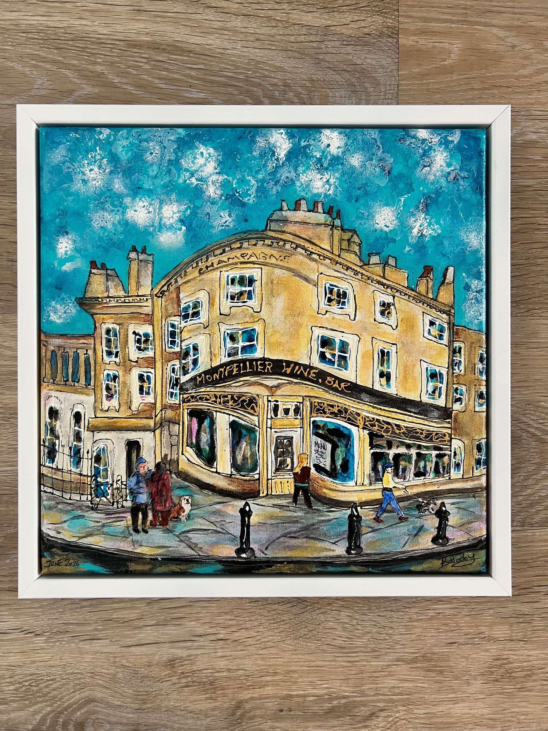 Colorful painting of a building with a tree in front. Yellow/purple building, blue sky, framed.