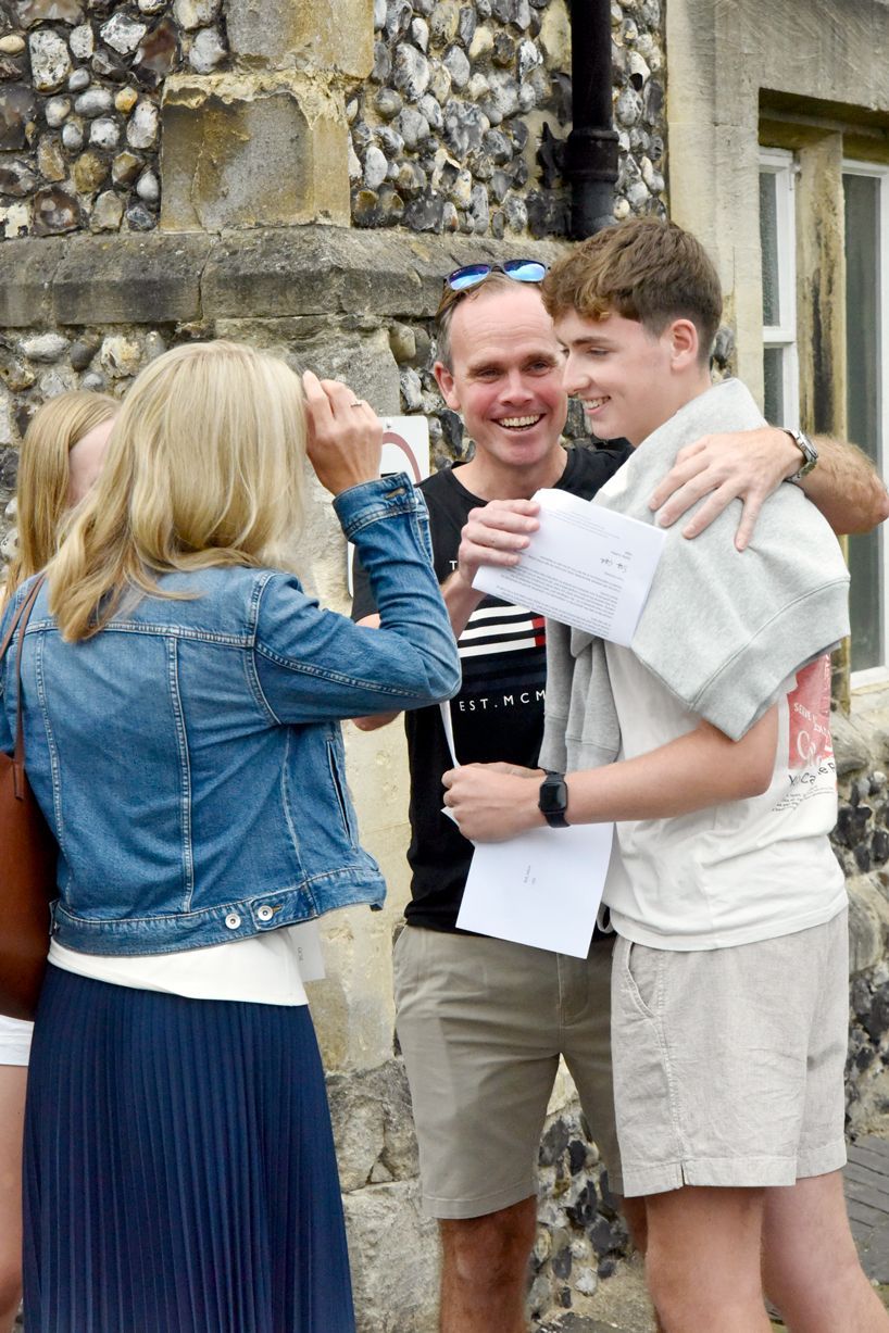 A group of people are standing next to each other in front of a building.