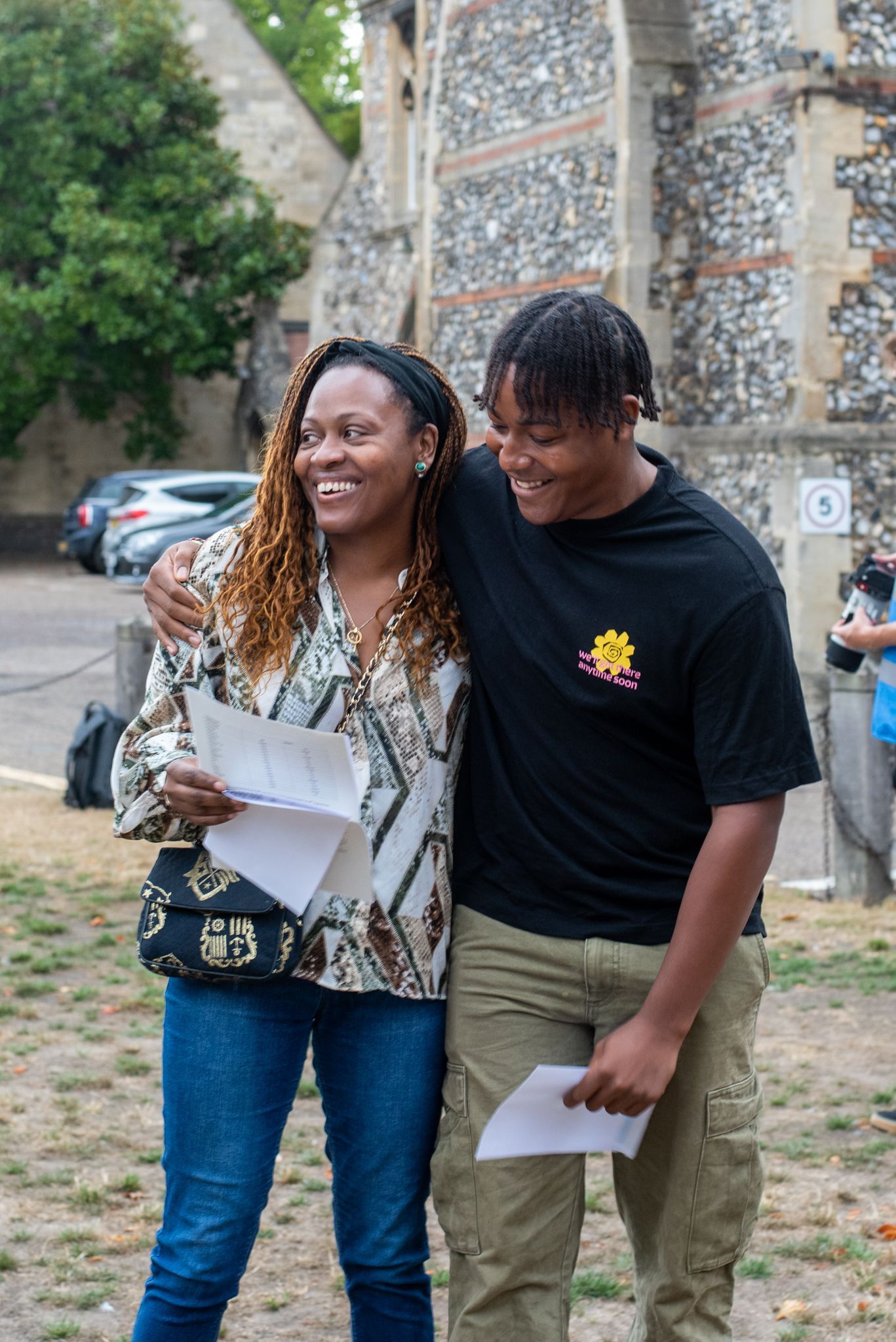 A man and a woman are standing next to each other in front of a building.