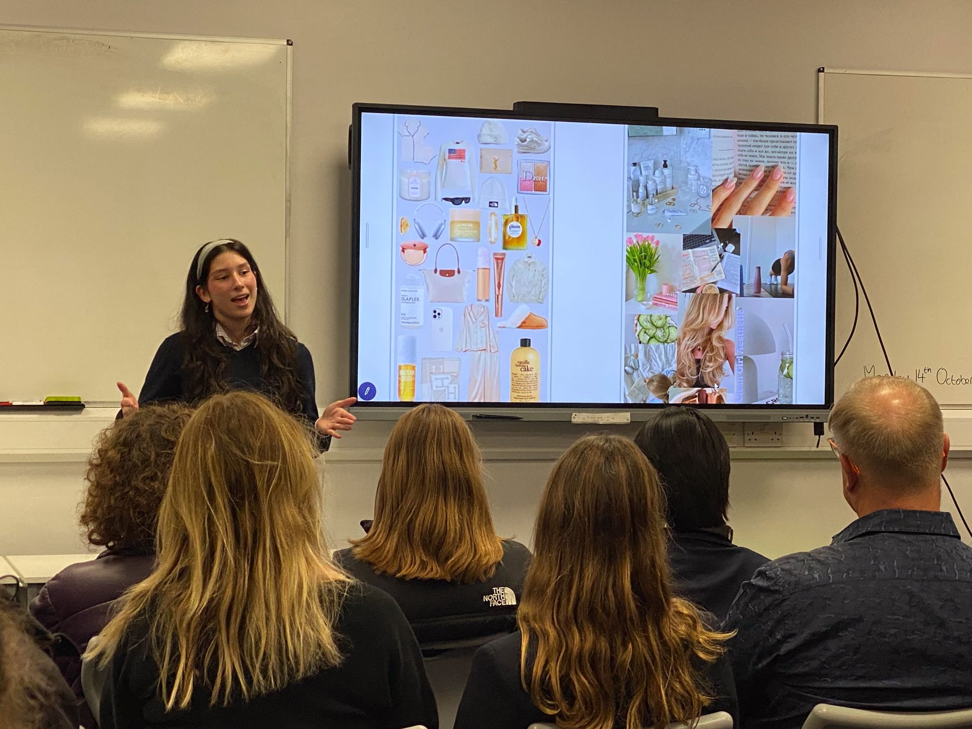 A woman is giving a presentation to a group of people in a classroom.