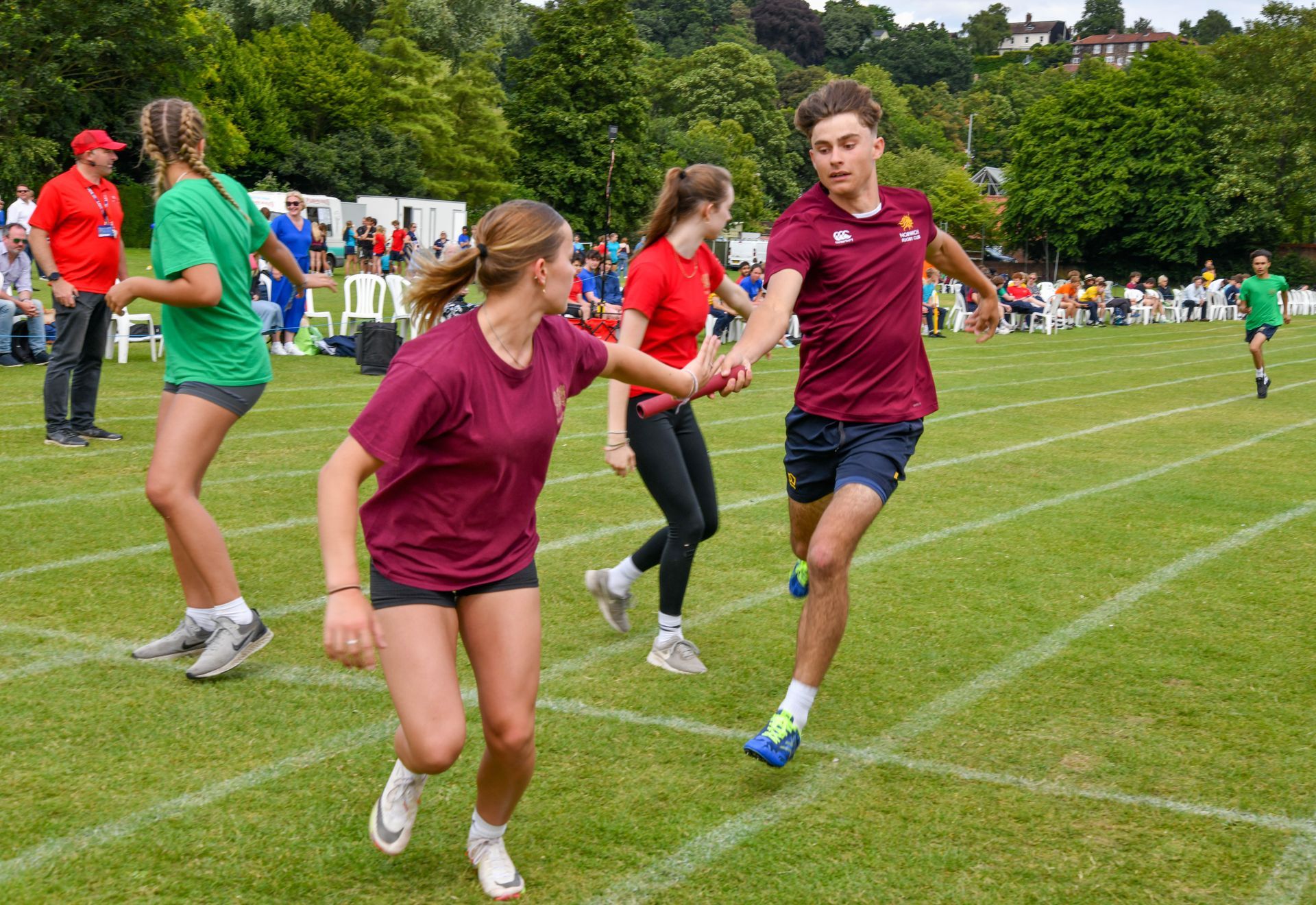 A group of people are running on a field holding hands.