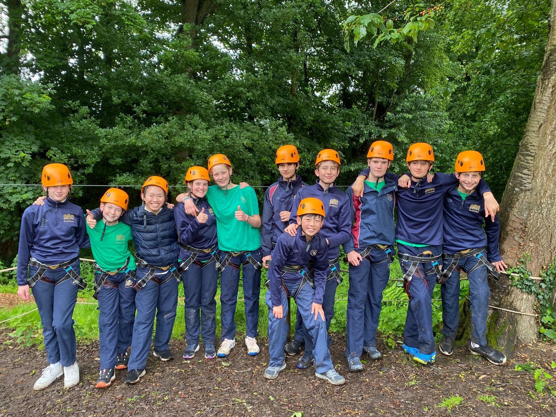 A group of young people wearing helmets are posing for a picture.