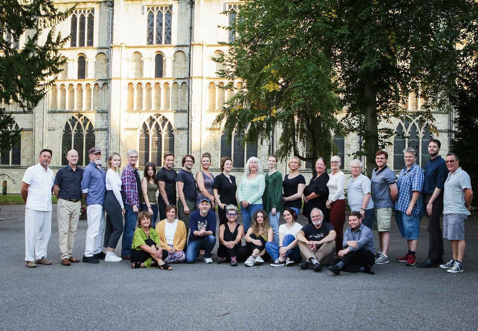 A large group of people are posing for a picture in front of a building.