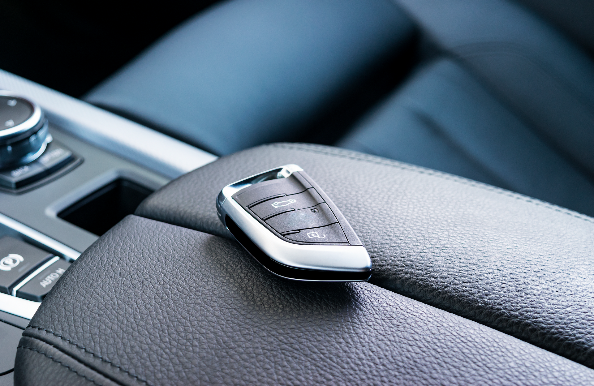 A car key is sitting on the center console of a car.