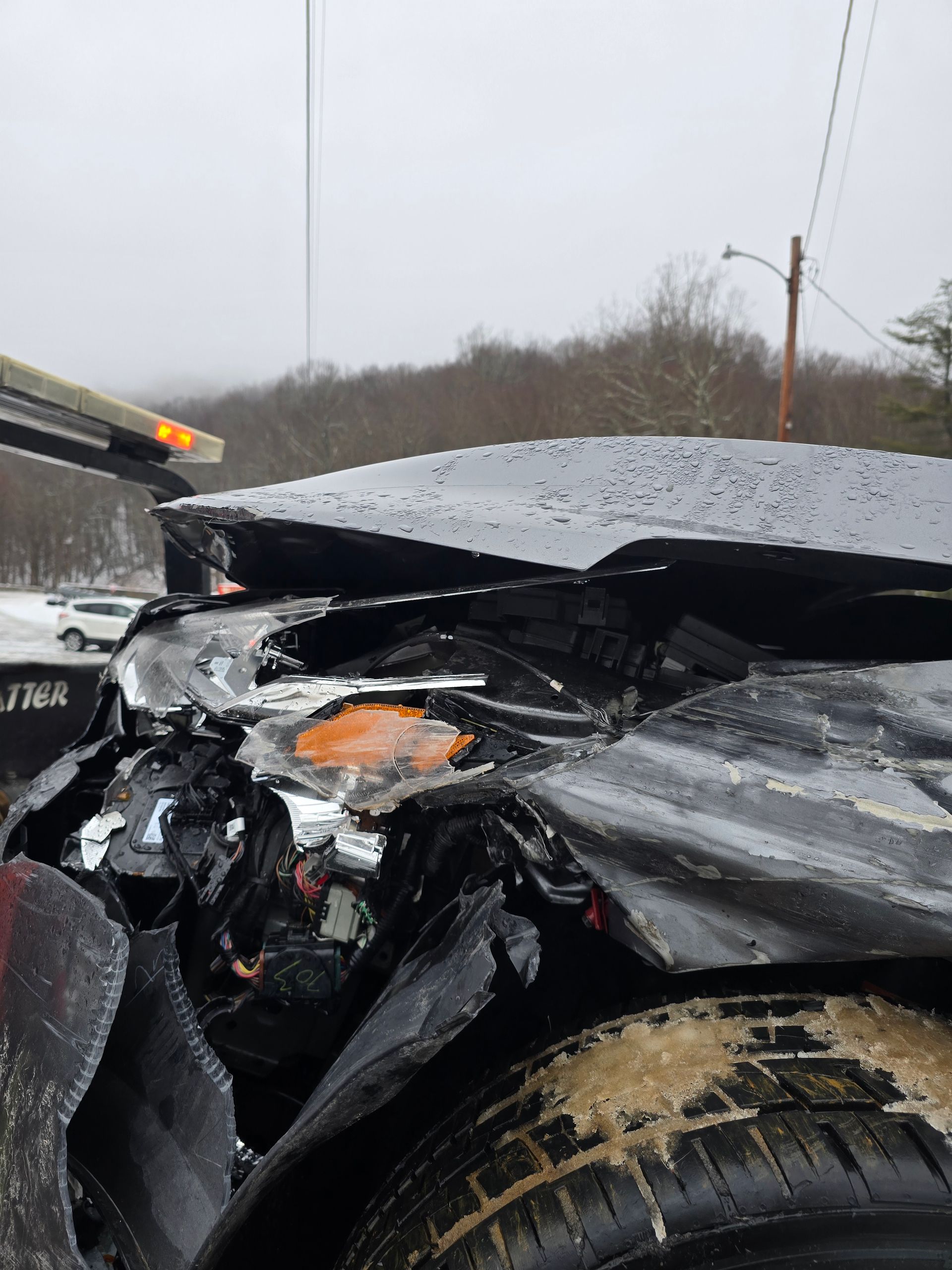 A white car is parked on top of a large rock.