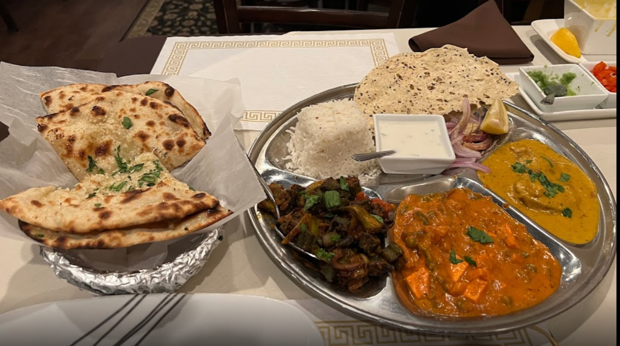Indian food platter with naan, rice, vegetables, and paneer in a restaurant.