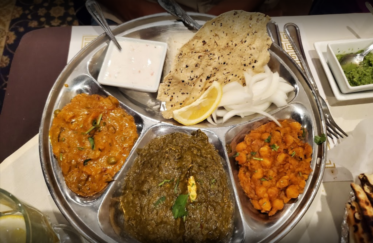Indian thali platter: various curries, rice, papadum, yogurt, and condiments.