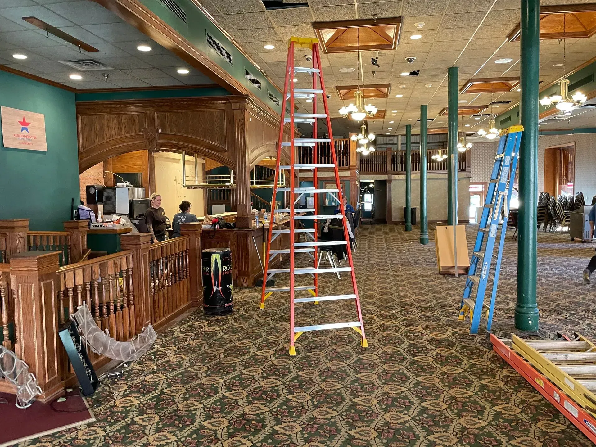 Restaurant interior with ladders and construction materials, suggesting ongoing renovation.