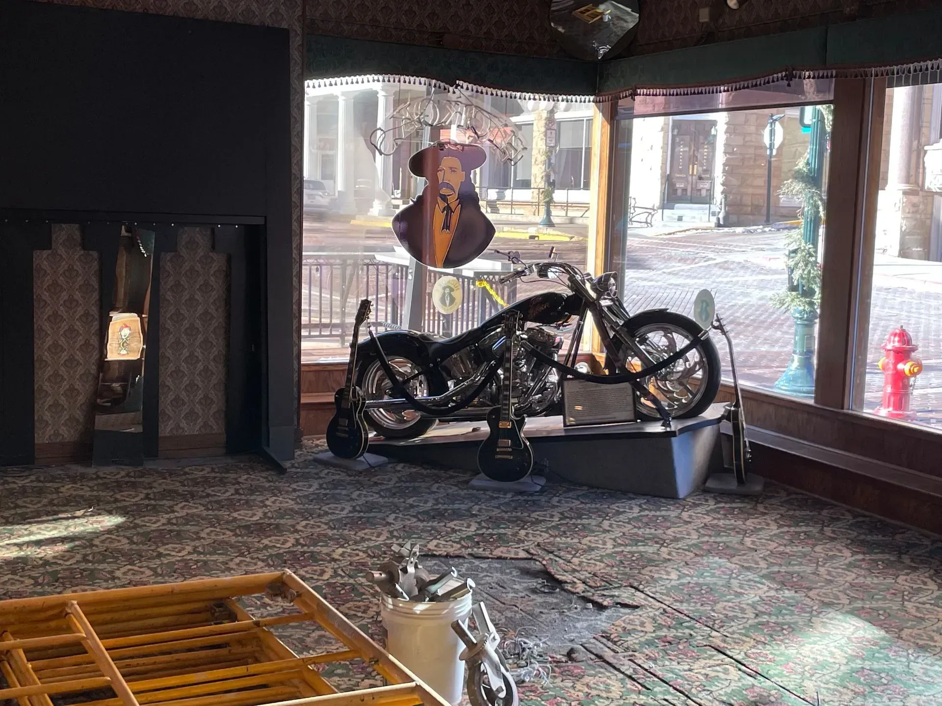 Black motorcycle displayed inside a shop with large front windows and a patterned floor.