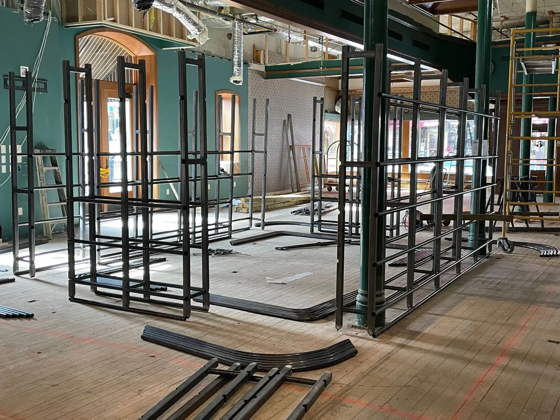Abandoned storefront under renovation with metal framing, exposed ceiling, and scattered construction materials