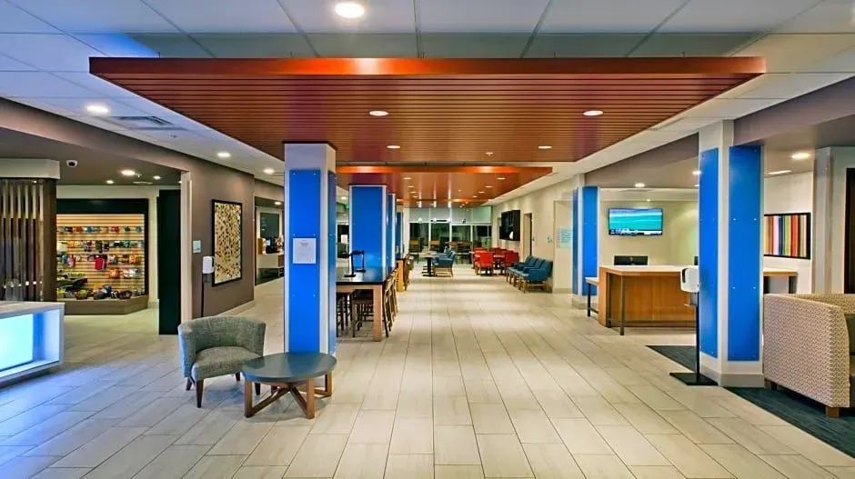 Modern hotel lobby with blue columns, wood ceiling accents, seating, and reception desks