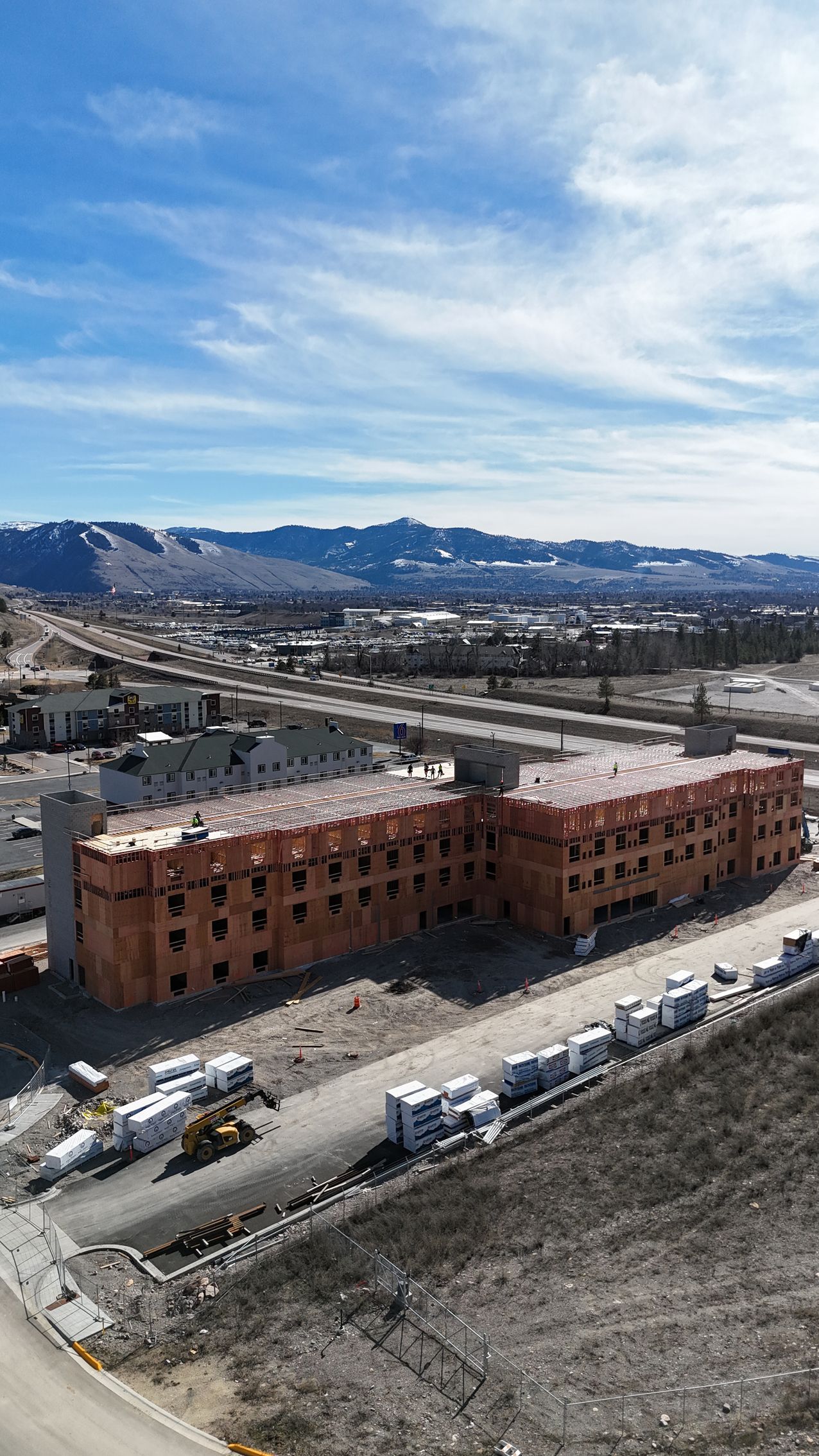 Snowy mountain town with red brick apartment buildings under a bright blue sky