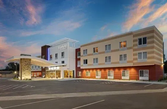 Modern hotel building at dusk with warm lights and a blue-pink sky