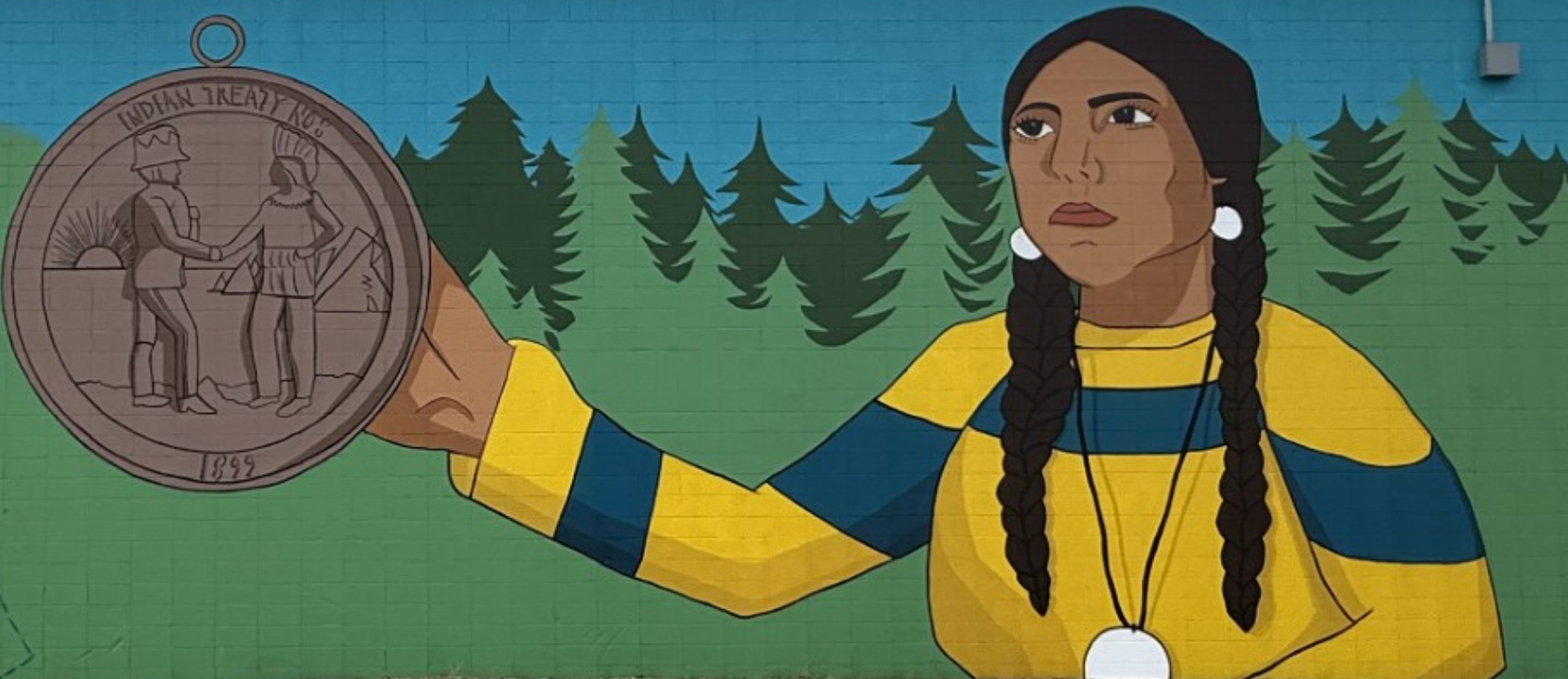 A mural of a person holding a Peace and Friendship medal against a backdrop of a pine forest under a blue sky.
