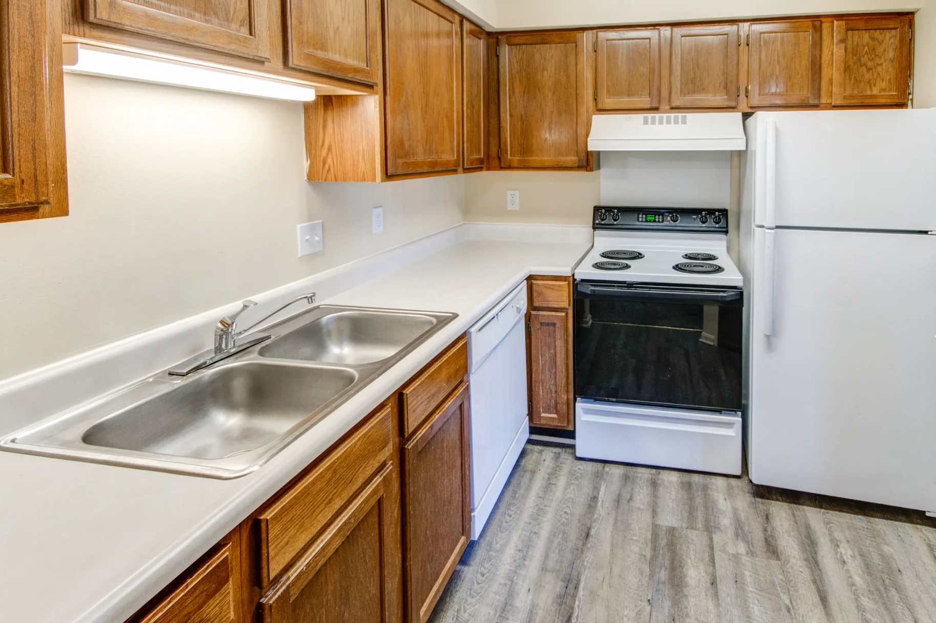 A kitchen with a stove , sink , refrigerator and dishwasher.