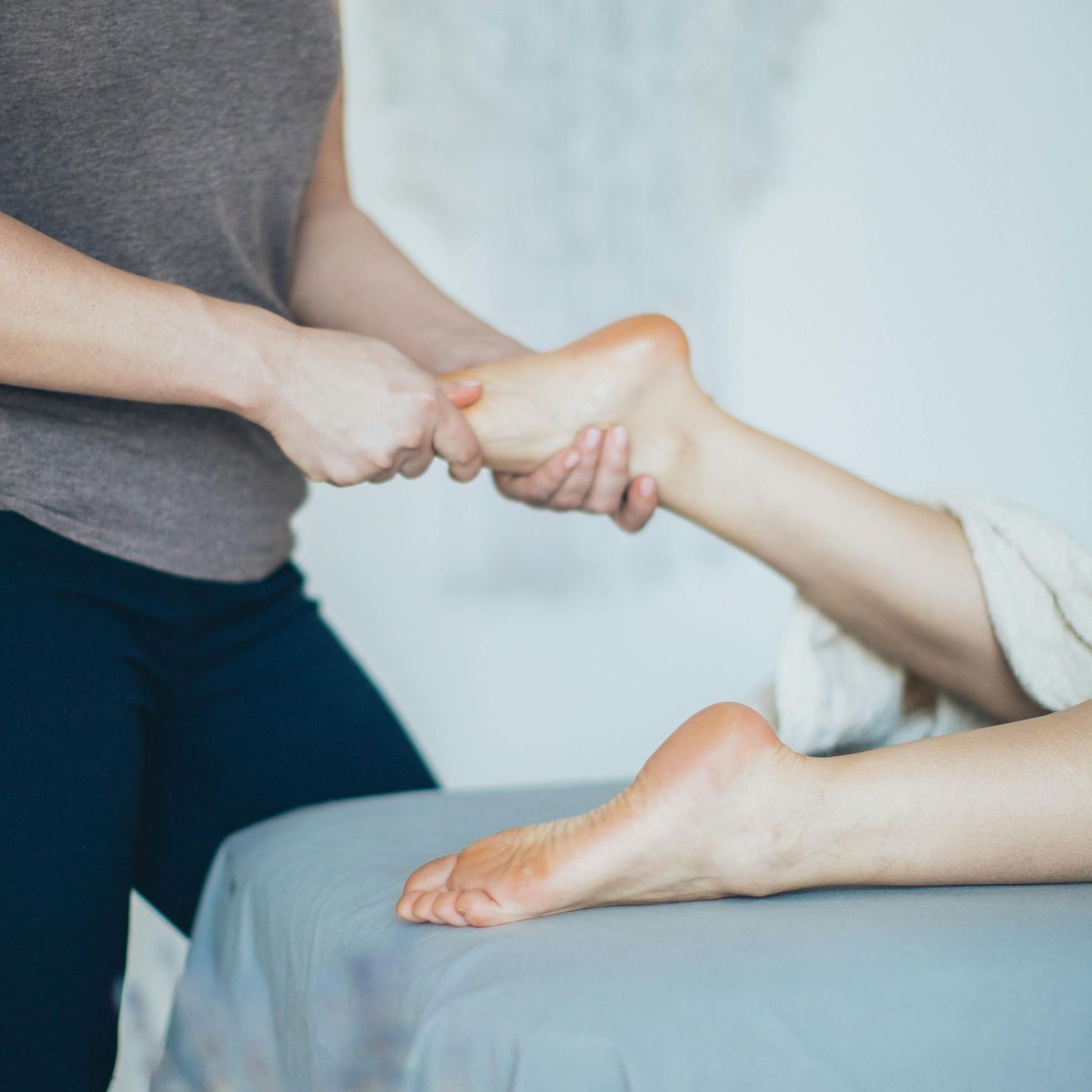 A woman is giving a foot massage to another woman