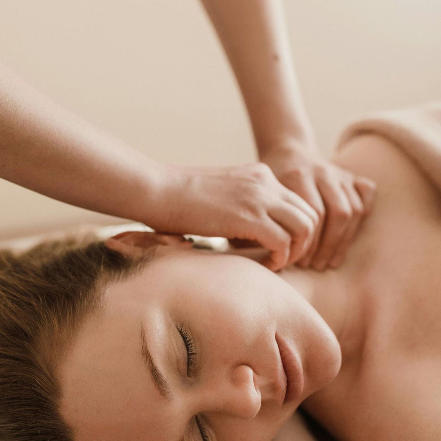A woman is getting a massage with her eyes closed