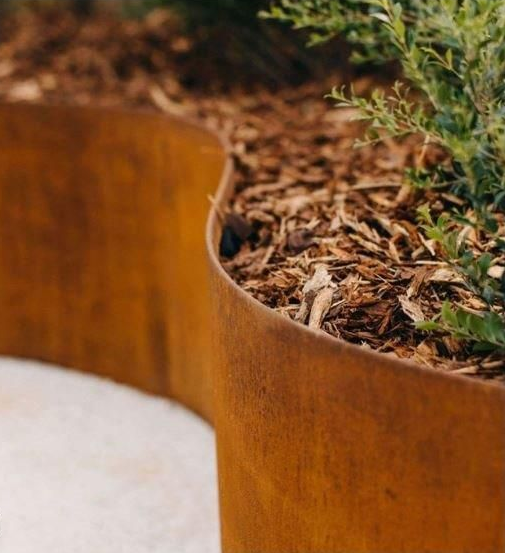 Curved Rusty Metal Planter Edge with Soil — Weldcro Fabrication in Ballina, NSW