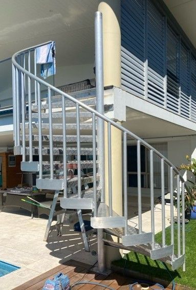 Curved Metal Spiral Staircase Beside a House — Weldcro Fabrication in Ballina, NSW