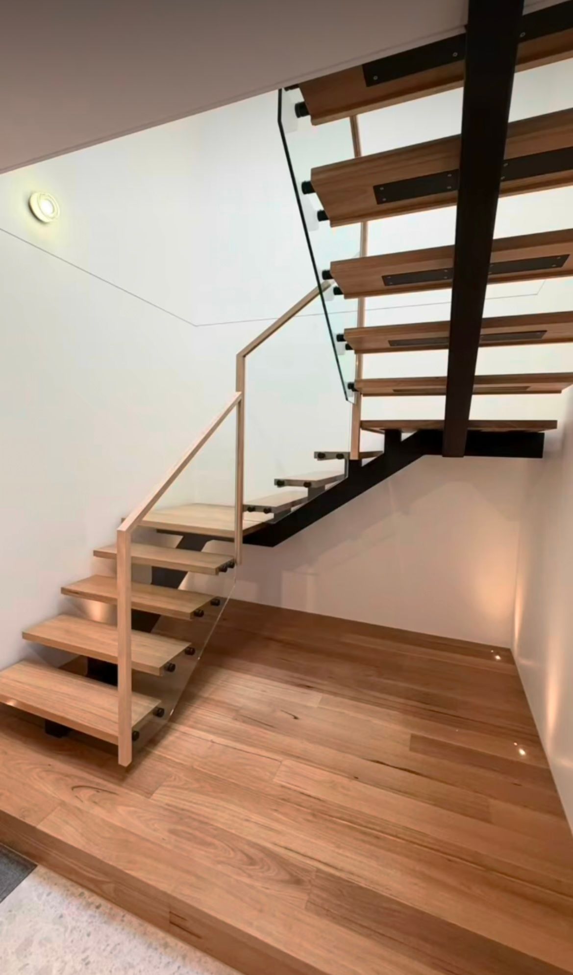 Wooden Staircase with Black Steel Supporting Stairs and Glass Balustrade — Weldcro Fabrication in Ballina, NSW