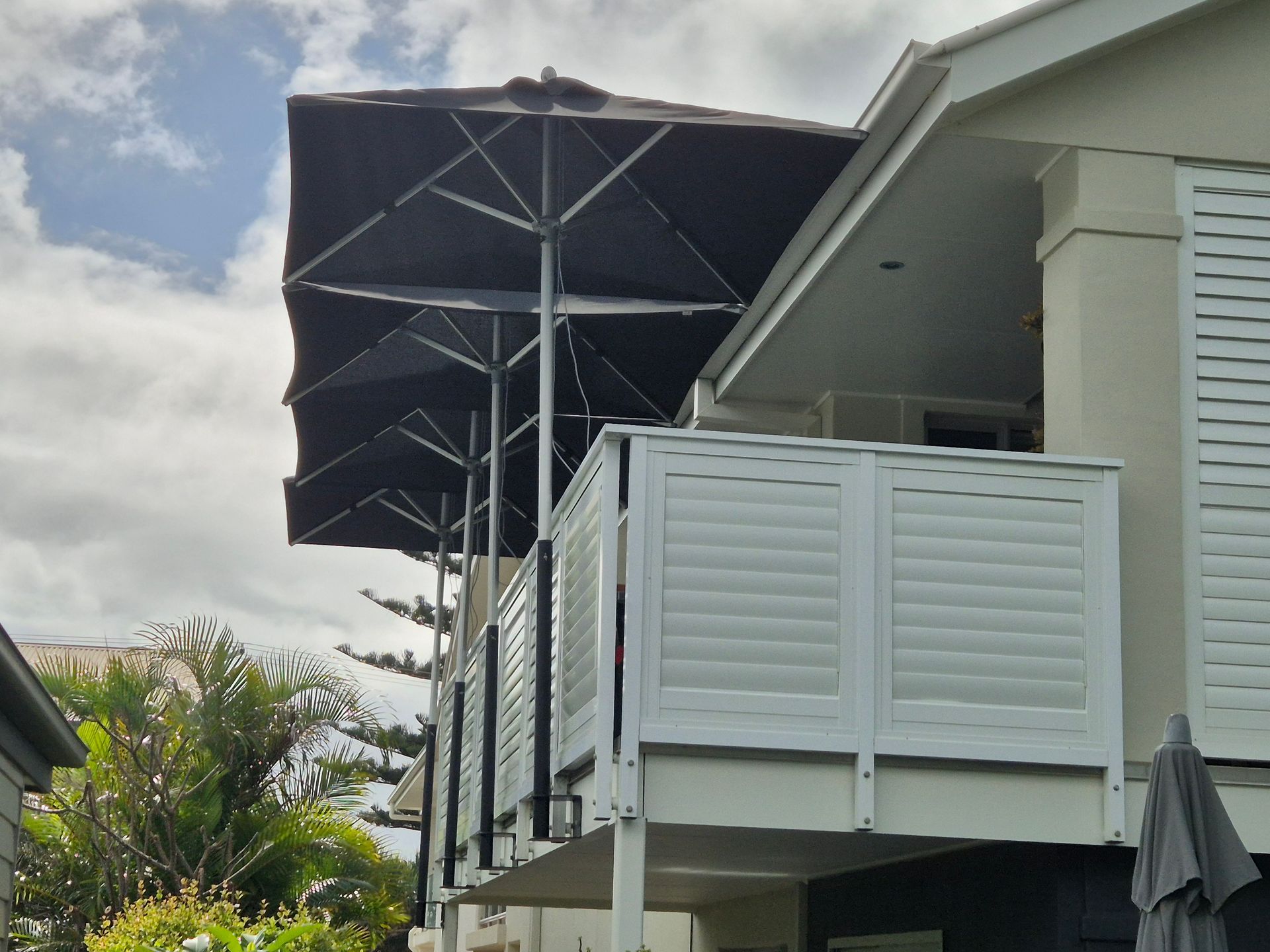 External Balcony with Metal Louvered Sides and Black Umbrella Shades — Weldcro Fabrication in Ballina, NSW