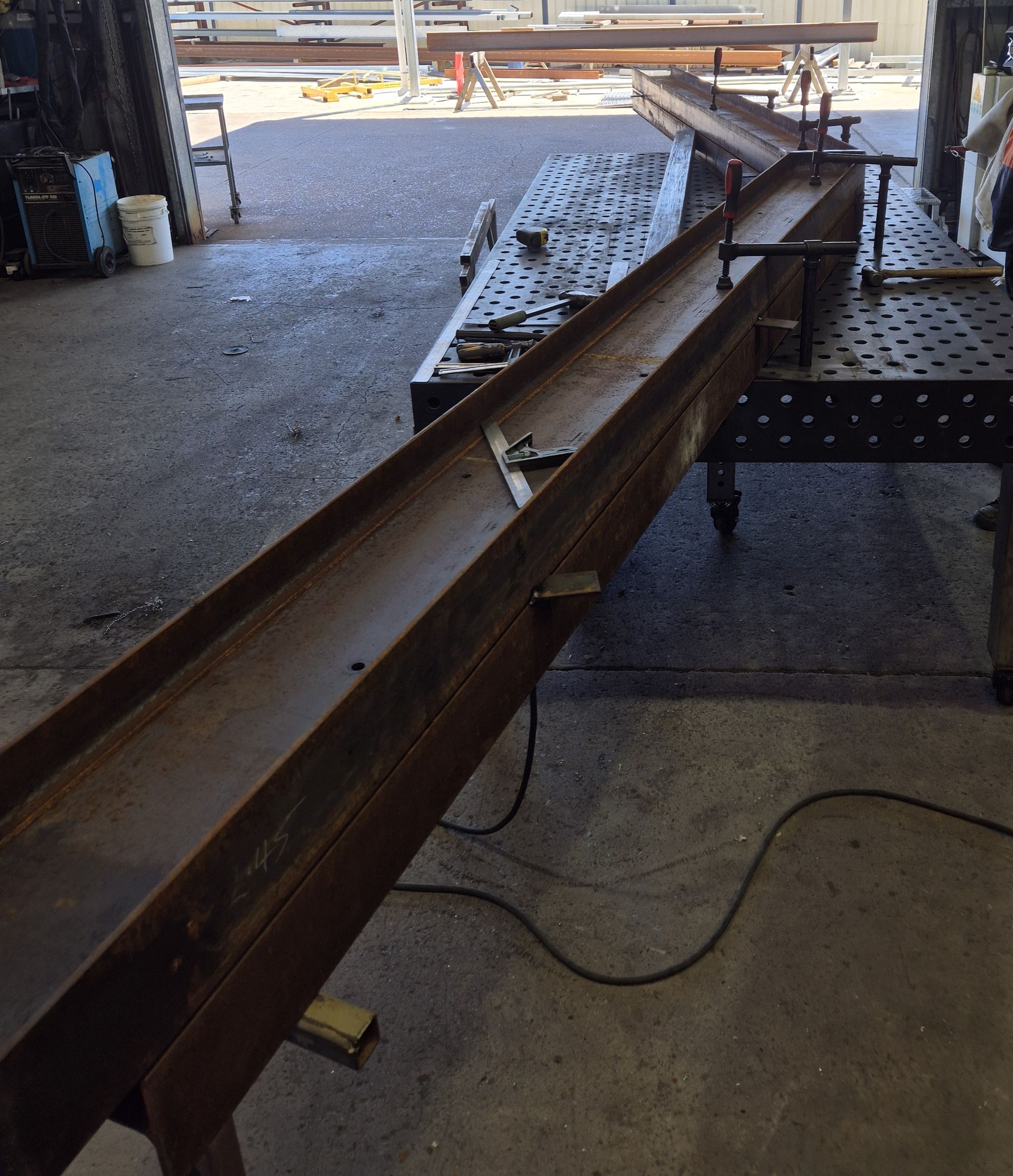 Long Rusted Steel Beam on a Construction Site With Gravel and Scaffolding Support — Weldcro Fabrication in Ballina, NSW